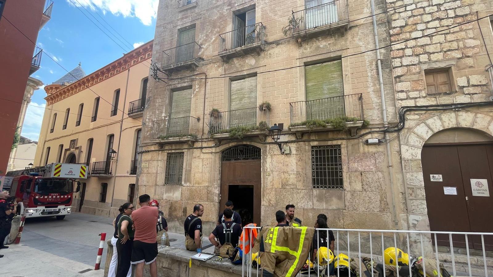 Efectivos de los bomberos ante un edificio de Tortosa derrumbado parcialmente.