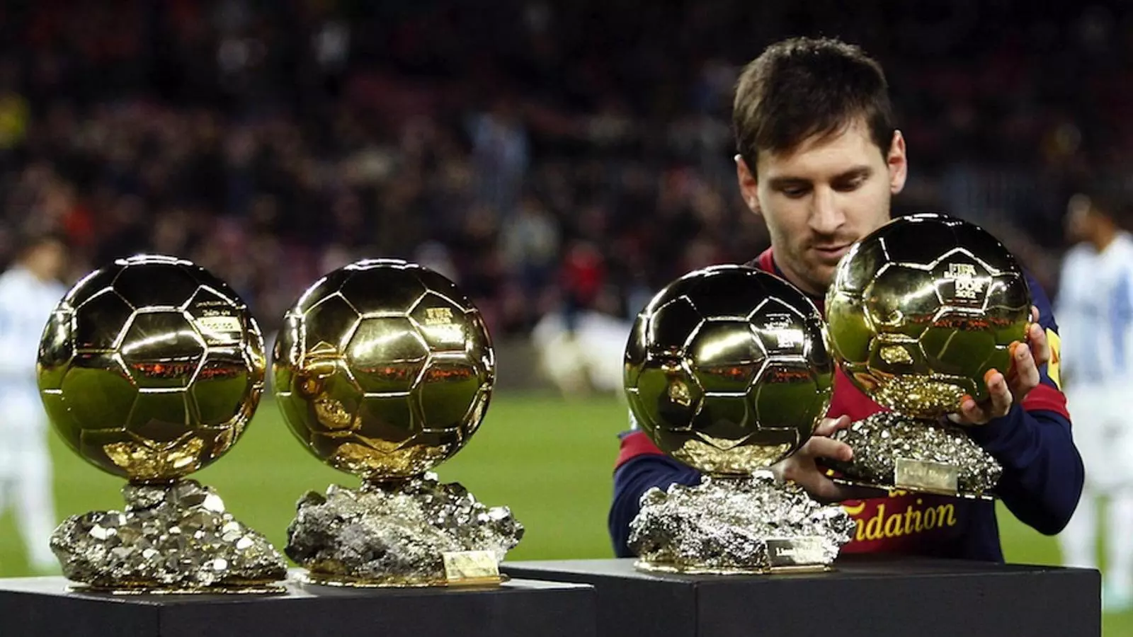 Leo Messi, amb les quatre Pilotes d'Or al Camp Nou / ALBERT OLIVÉ / EFE