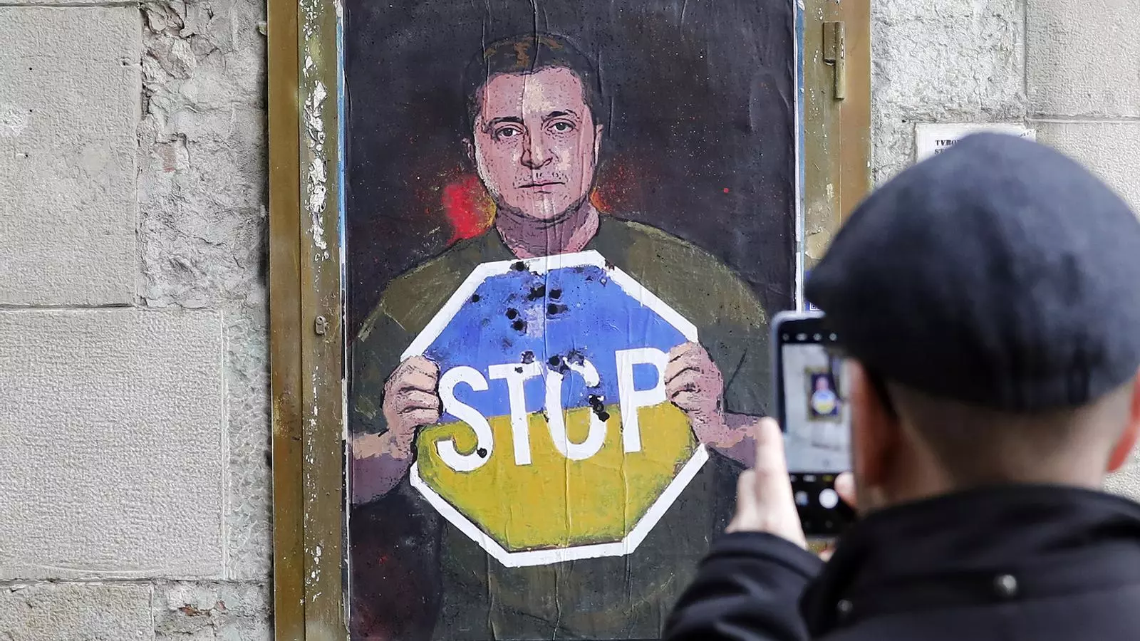 Obra del graffiter Tvboy en el centro de Barcelona en la que aparece Zelenski con una señal de Stop pintada con los colores de la bandera ucraniana.