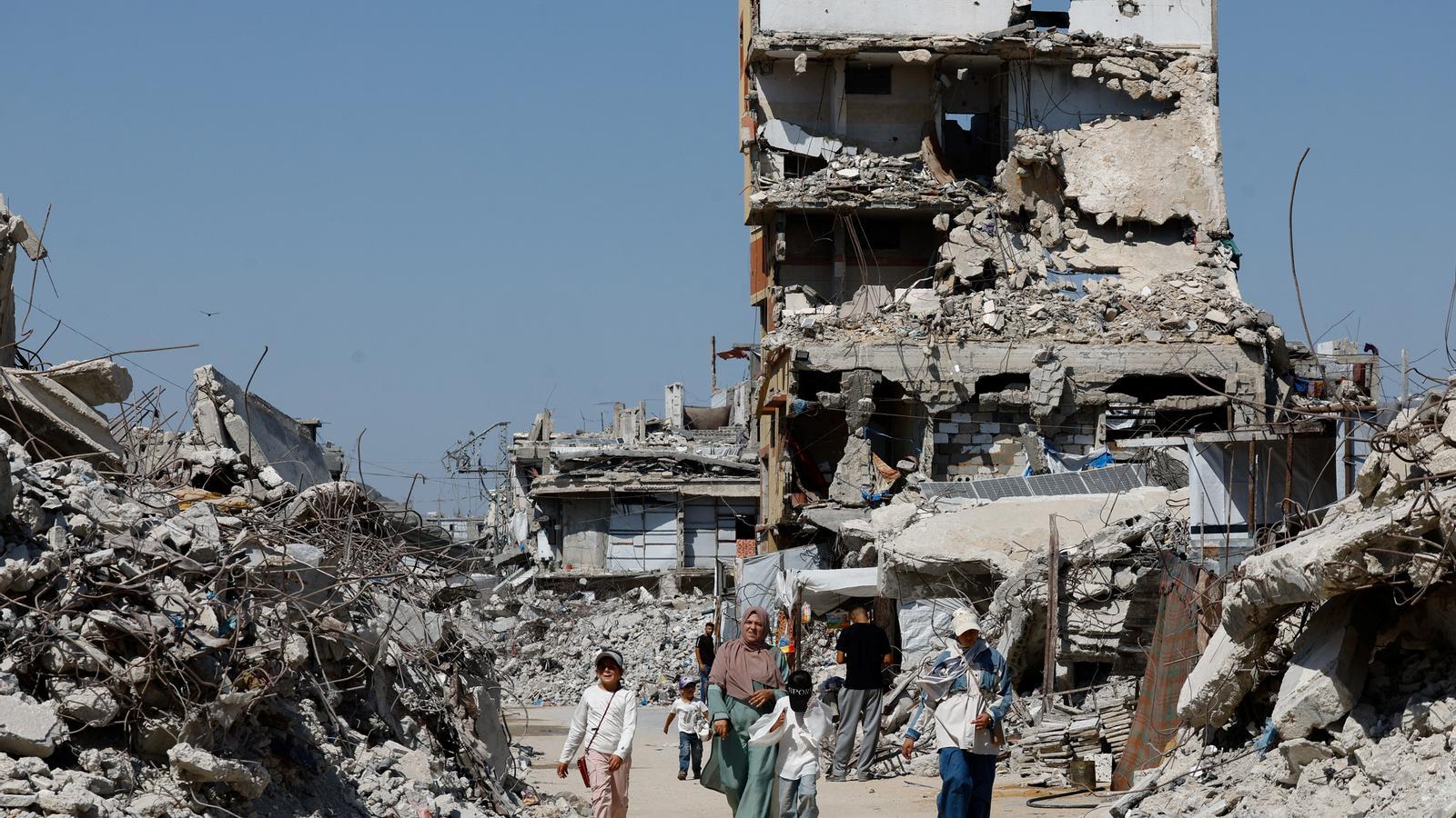Palestinians walk among the rubble in Jabalia, in the north of the Gaza Strip.