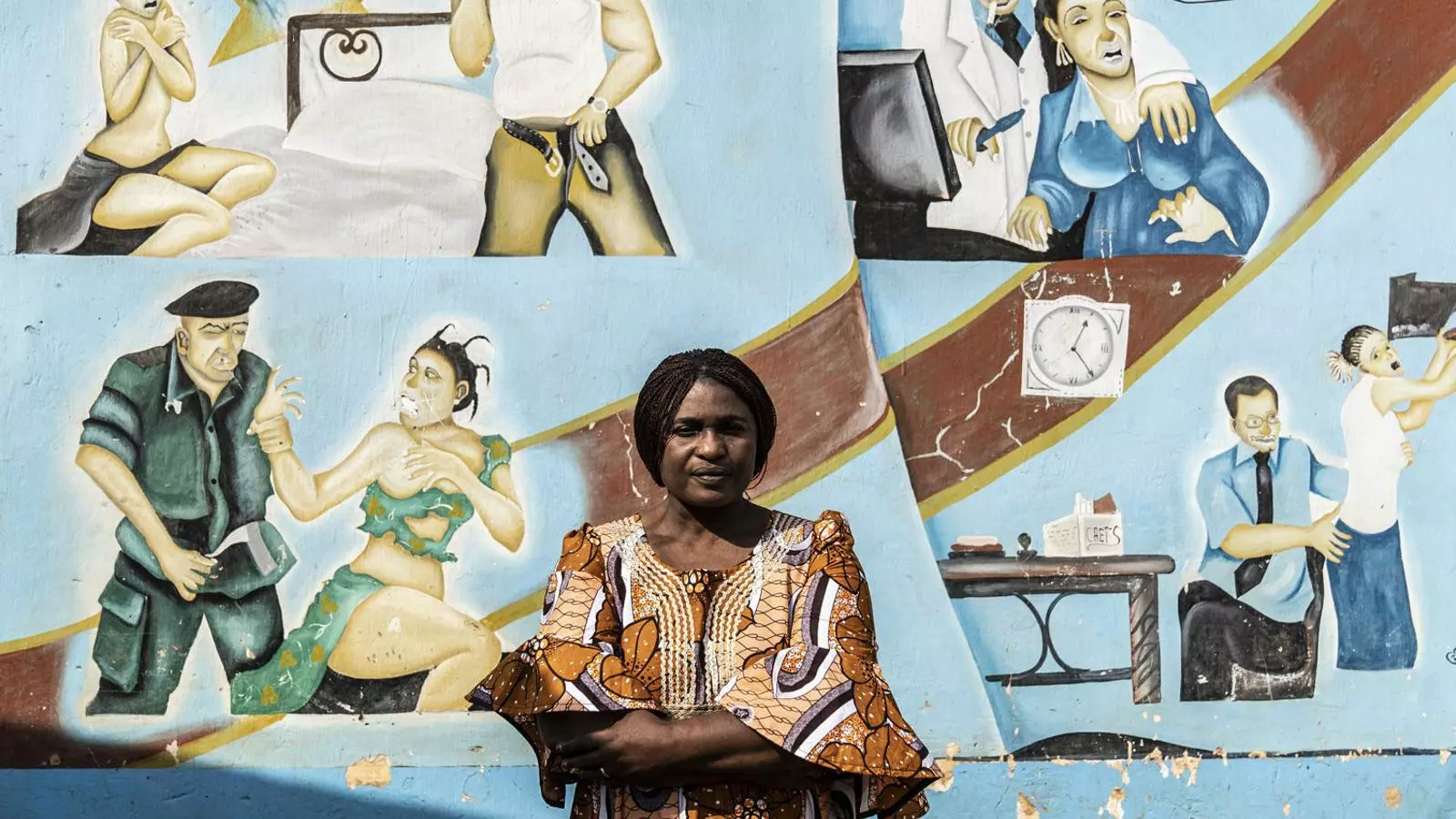 La coronel Esther Kalumbu posant davant el mural de la comissaria amb escenes de violència contra les dones
