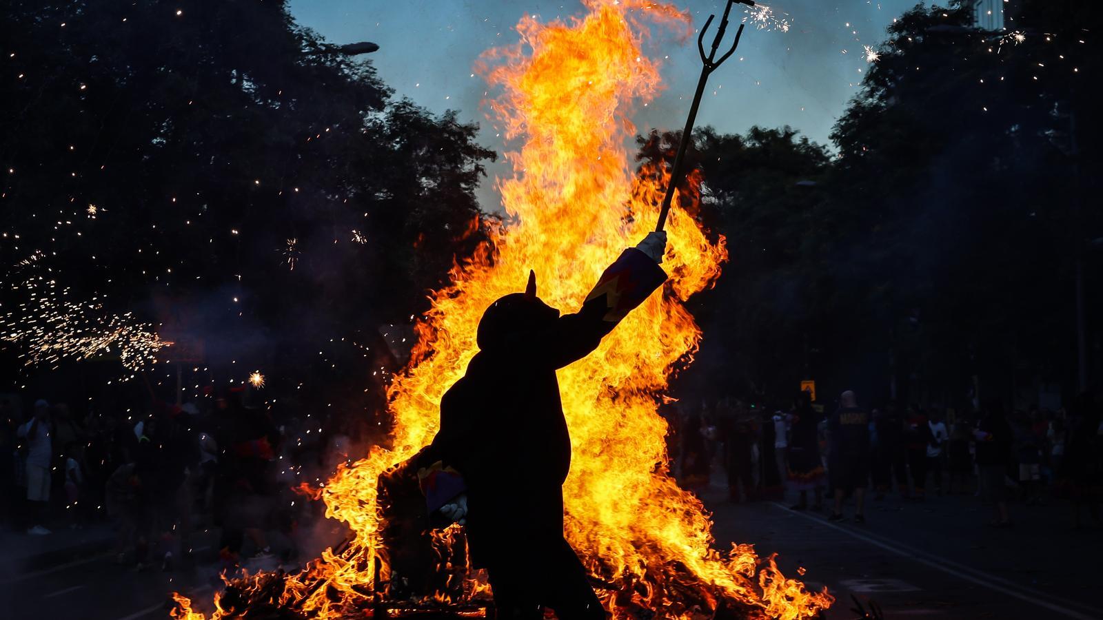 A devil dancing next to the bonfire, in the Barcelona neighborhood of La Sagrera.
