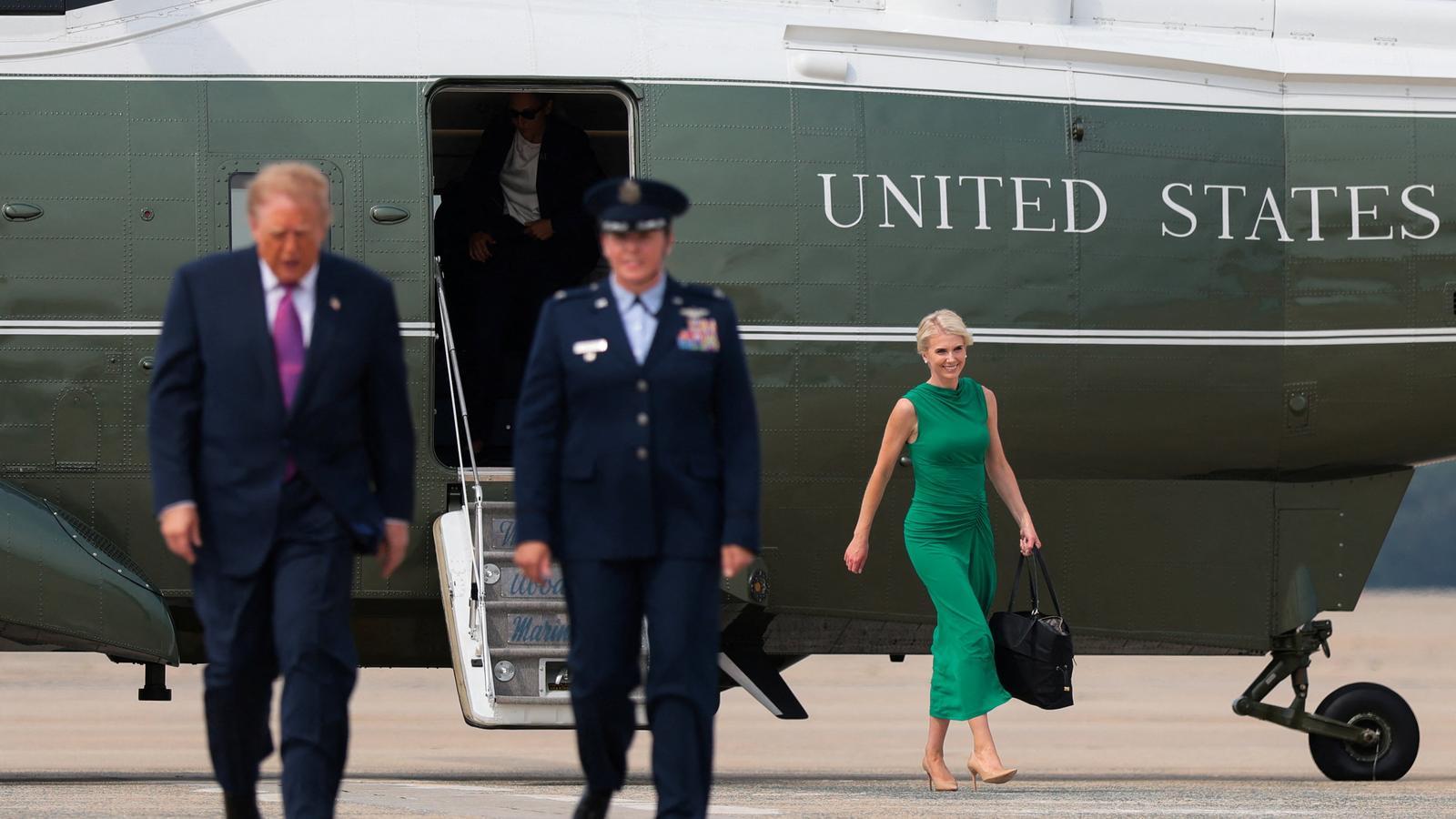 El presidente Donald Trump bajando del Air Force One con su asistente Natalie Harp destacada en segundo plano.