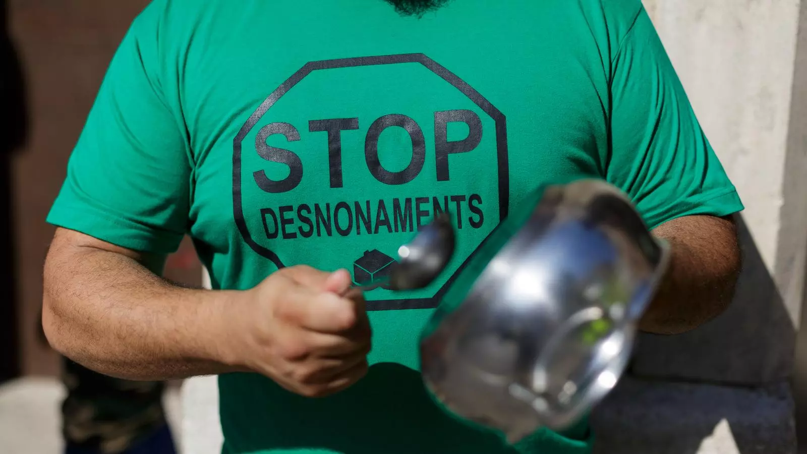 Un home amb una camiseta amb el lema Stop Desnonaments.