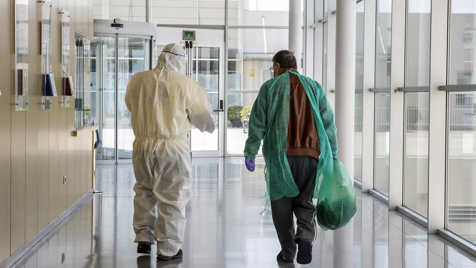 Un sanitari acompanya un pacient de coronavirus en el moment de ser donat d'alta a l'Institut Guttmann