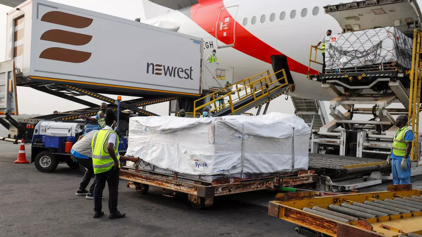 Operaris de terra de l'aeroport d'Accra, a Ghana, descarreguen aquest dimecres les primeres dosis de la vacuna d'Oxford, que arriben a l´Àfrica