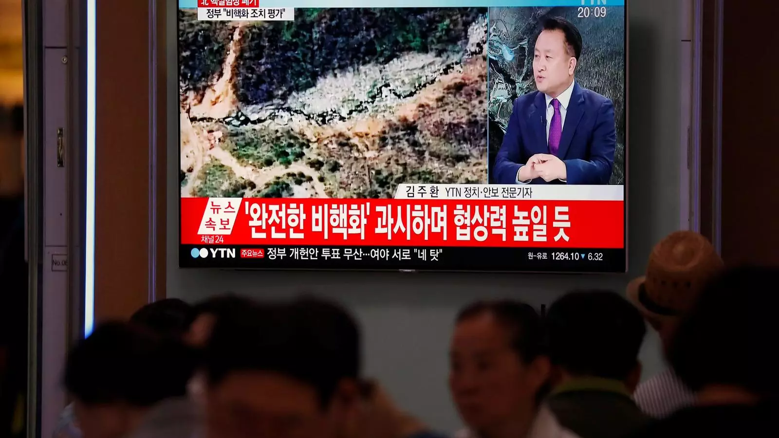 Ciutadans de Seül miren per la televisió el desmantellament de la base nuclear nord-coreana