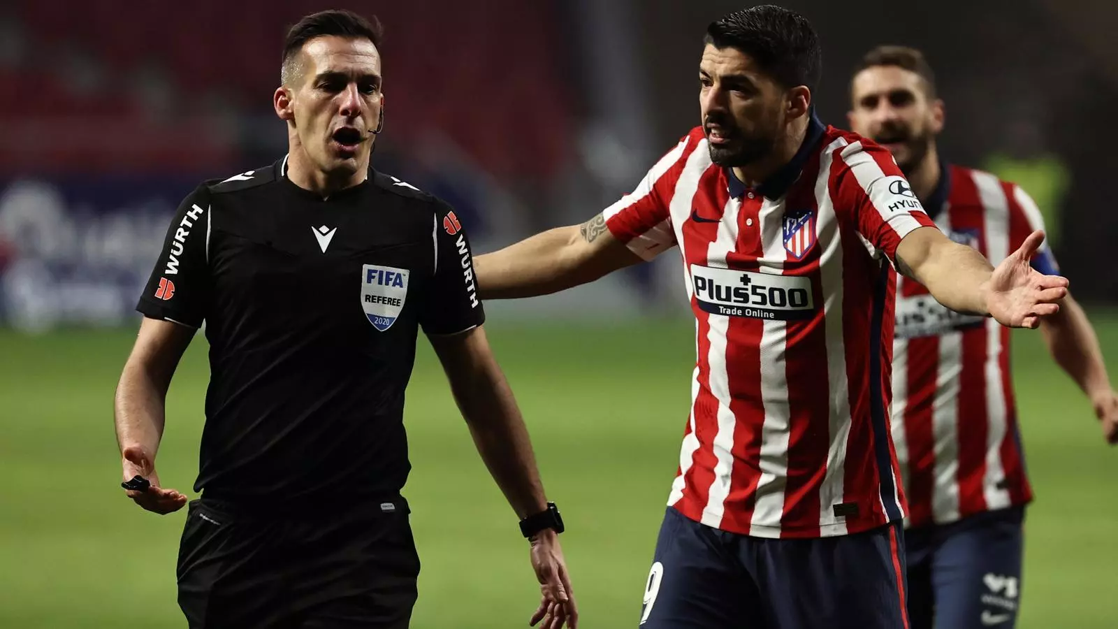 L'àrbitre Xavi Estrada Fernàndez, escuchando la protesta de Luis Suárez durante un partido del Atlético de Madrid