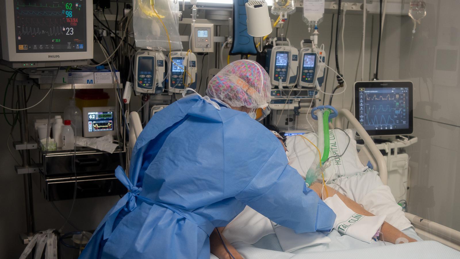 Una infermera atenent un malalt a la UCI de l'Hospital Clínic de Barcelona aquesta cinquena onada.