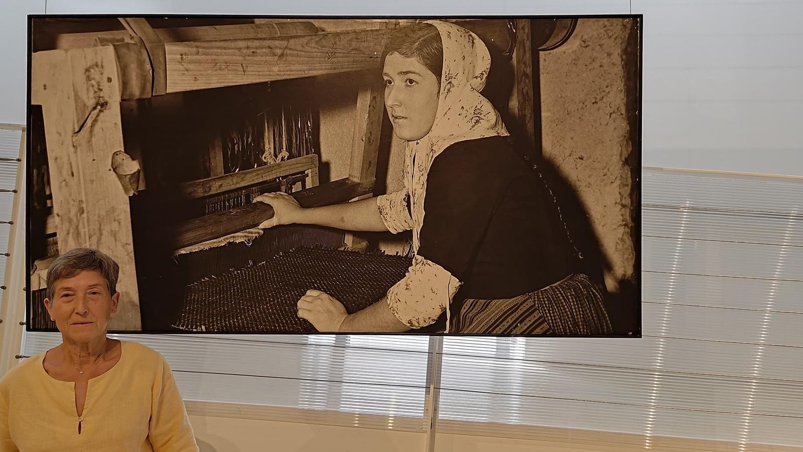 Francisca Coll Sampol junto a la foto que le hicieron de trenzado en 1965, a 13 años, para la Feria de la piel de Düsseldorf.