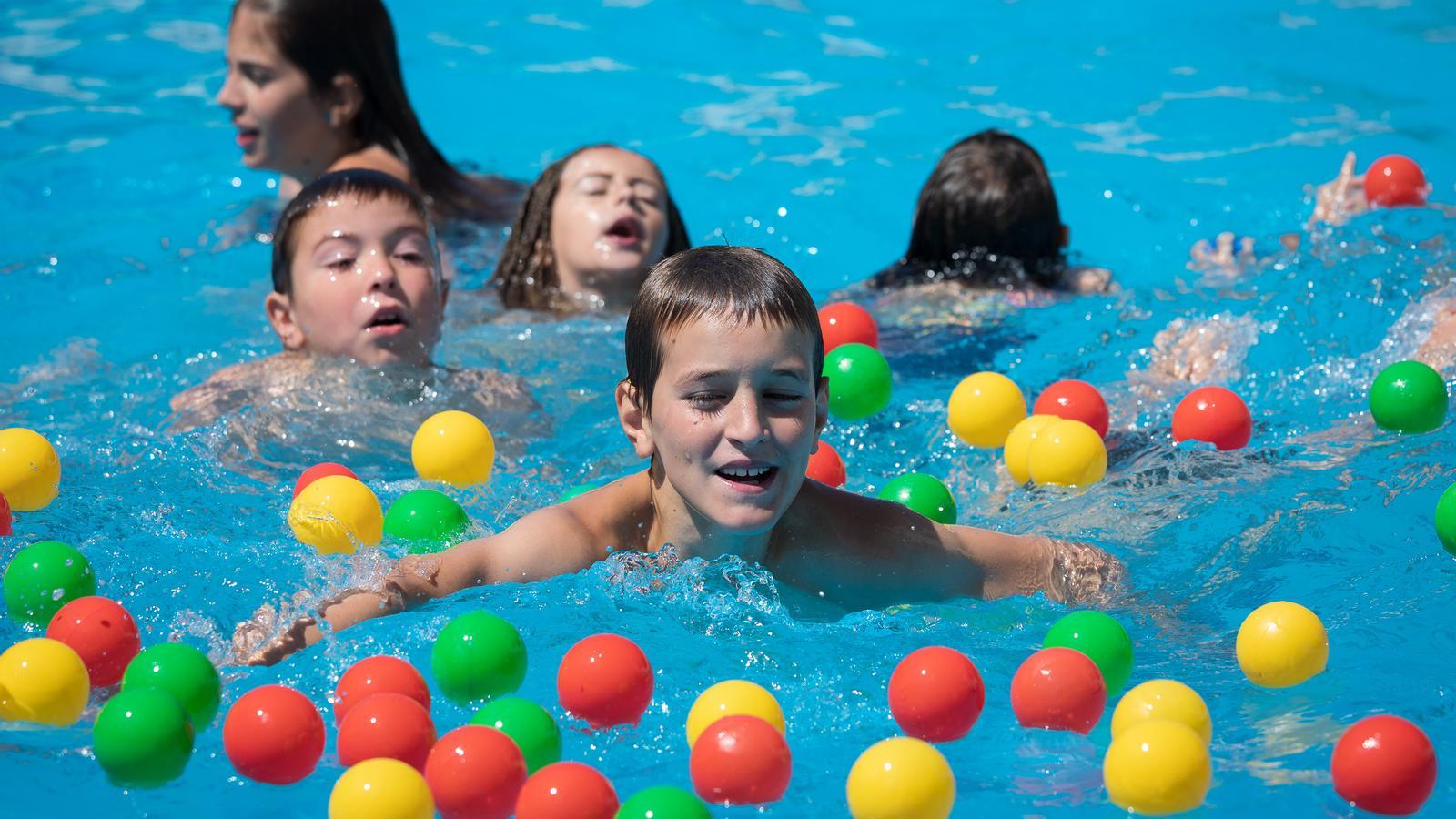 A group of boys and girls play in a swimming pool, in a file image