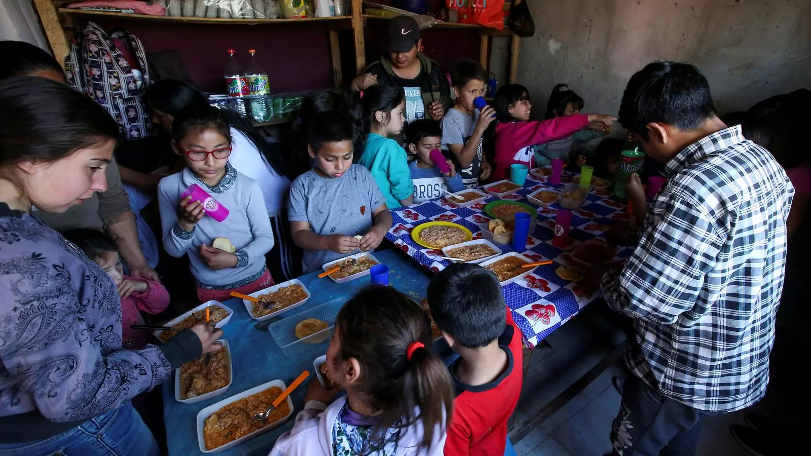 Un grup de menors menja en un menjador comunitari regentat per voluntaris a Claypole, una barriada dels afores de Buenos Aires