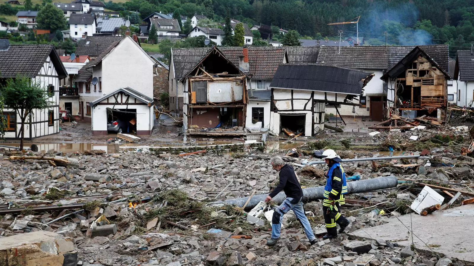 Un home i un bomber passegen per la runa després de les fortes pluges a Schuld, Alemanya