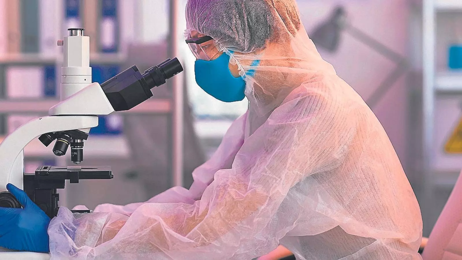 Un científic mirant per un microscopi en un laboratori.