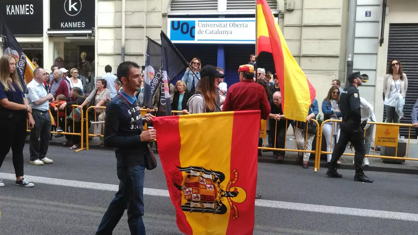 Un seguidor d'España 2000 llueix una bandera franquista durant la tradicional Processó Cívica del Nou d'Octubre a València