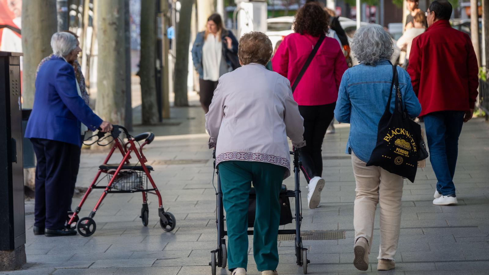 Two women with a walker, on a street in Cornellà de Llobregat.