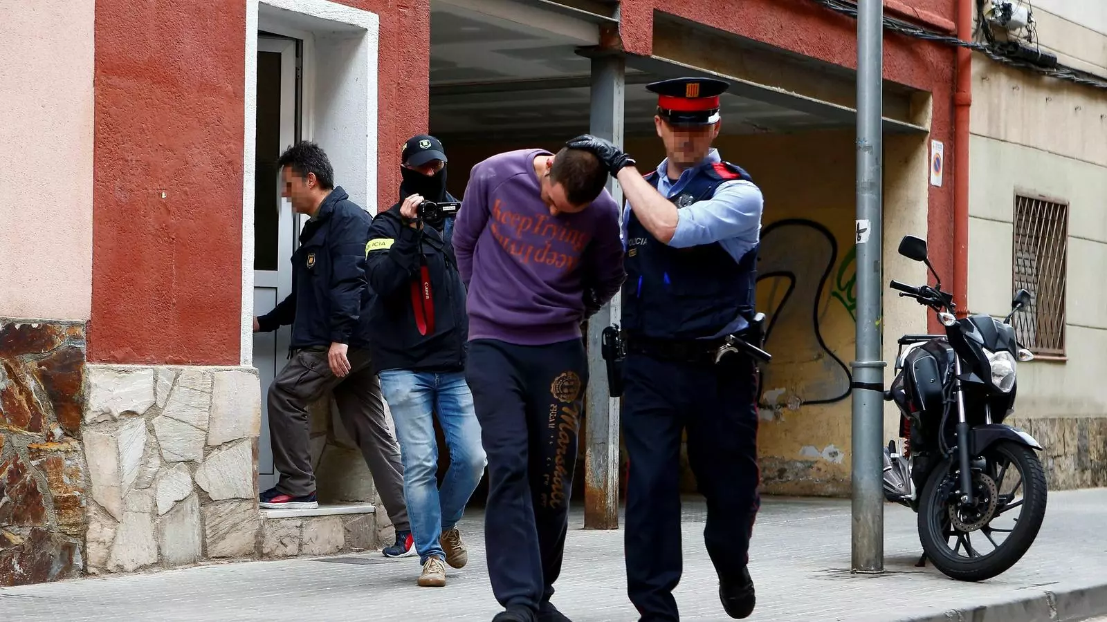 Un dels detinguts sortint del seu domicili de Cornellà, custodiat pels Mossos, després de l'escorcoll