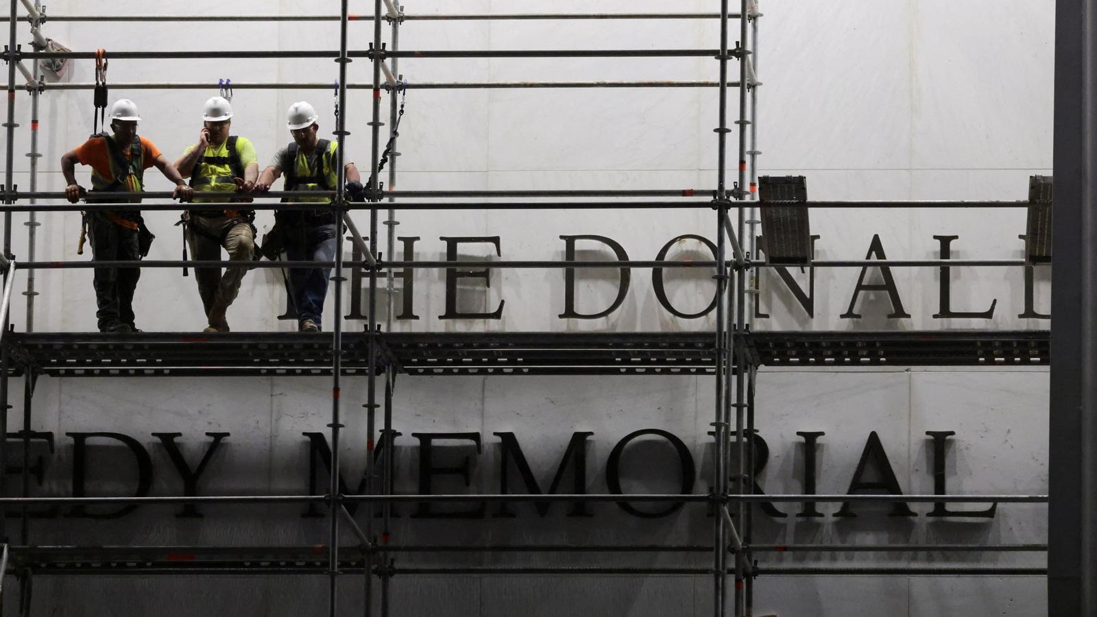 Workers on scaffolding to remove Donald Trump's name from the facade of the John F. Kennedy Memorial Center in Washington.