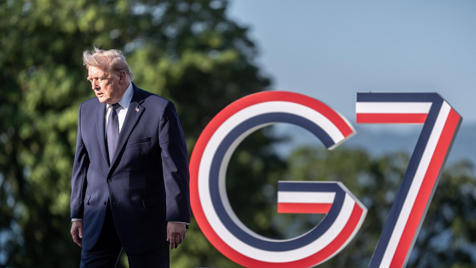 El presidente de los Estados Unidos, Donald Trump, se encuentra ante el emblema de la Cumbre al inicio de la Cumbre del G7