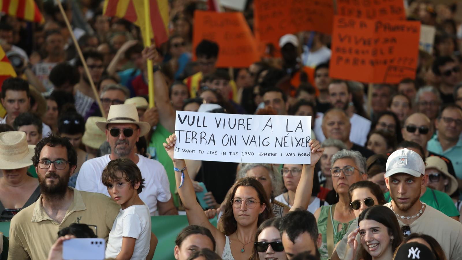 Una mujer muestra una pancarta durante una manifestación contra la masificación turística en Palma.
