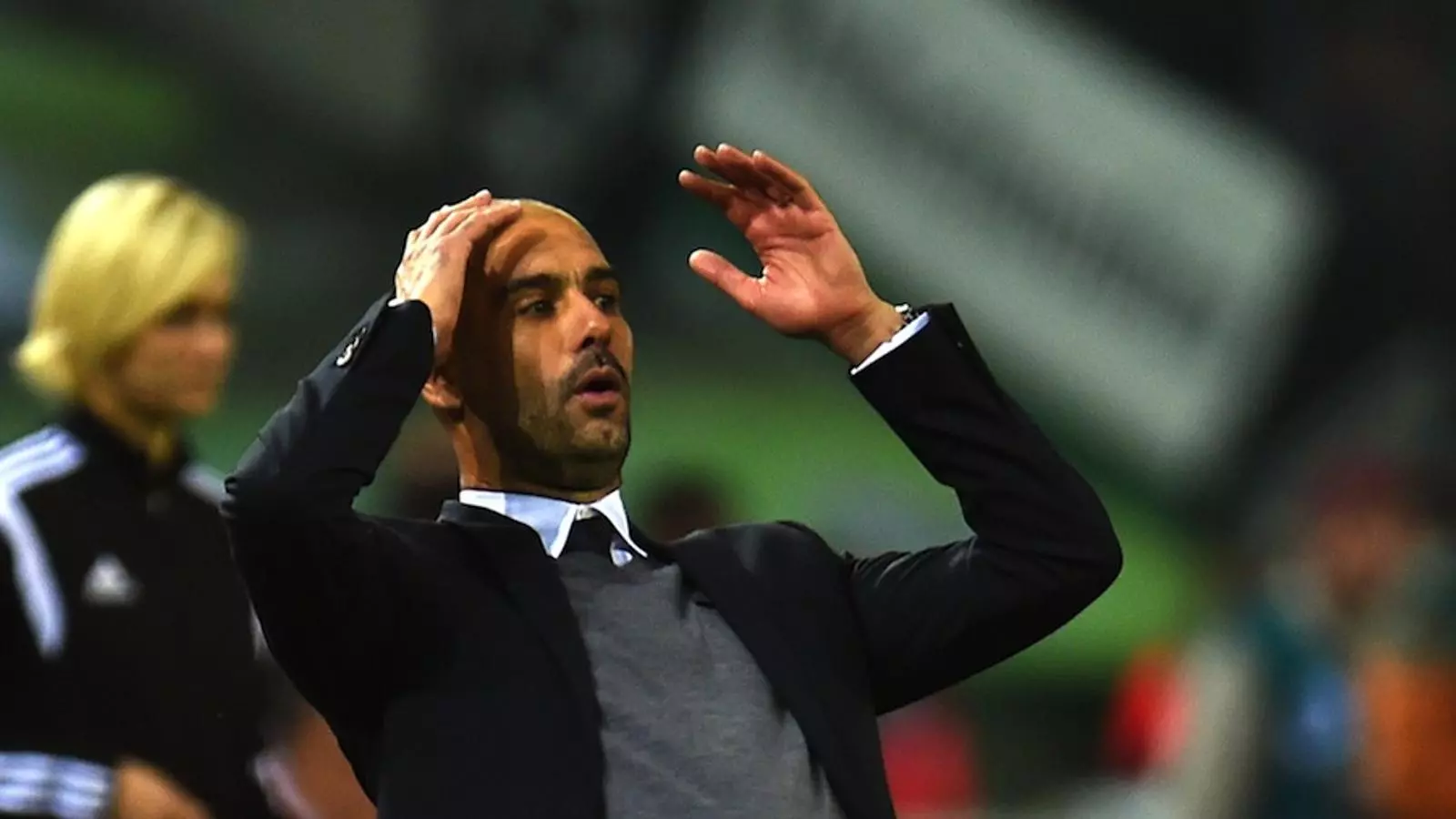 Pep Guardiola durant el partit d'aquest diumenge i, darrere, la quarta àrbitre Bibiana Steinhaus / PATRIK STOLLARZ / AFP