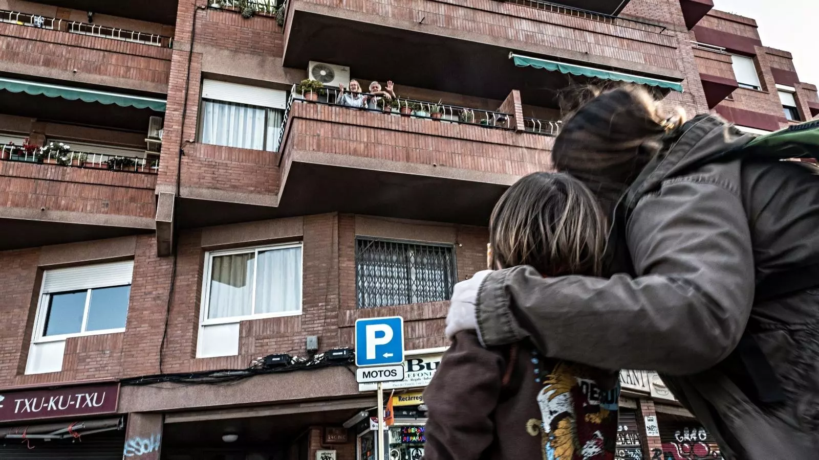 La Marta i el seu fill Bruno saluden als avis des del carrer al centre de Cornellà de Llobregat