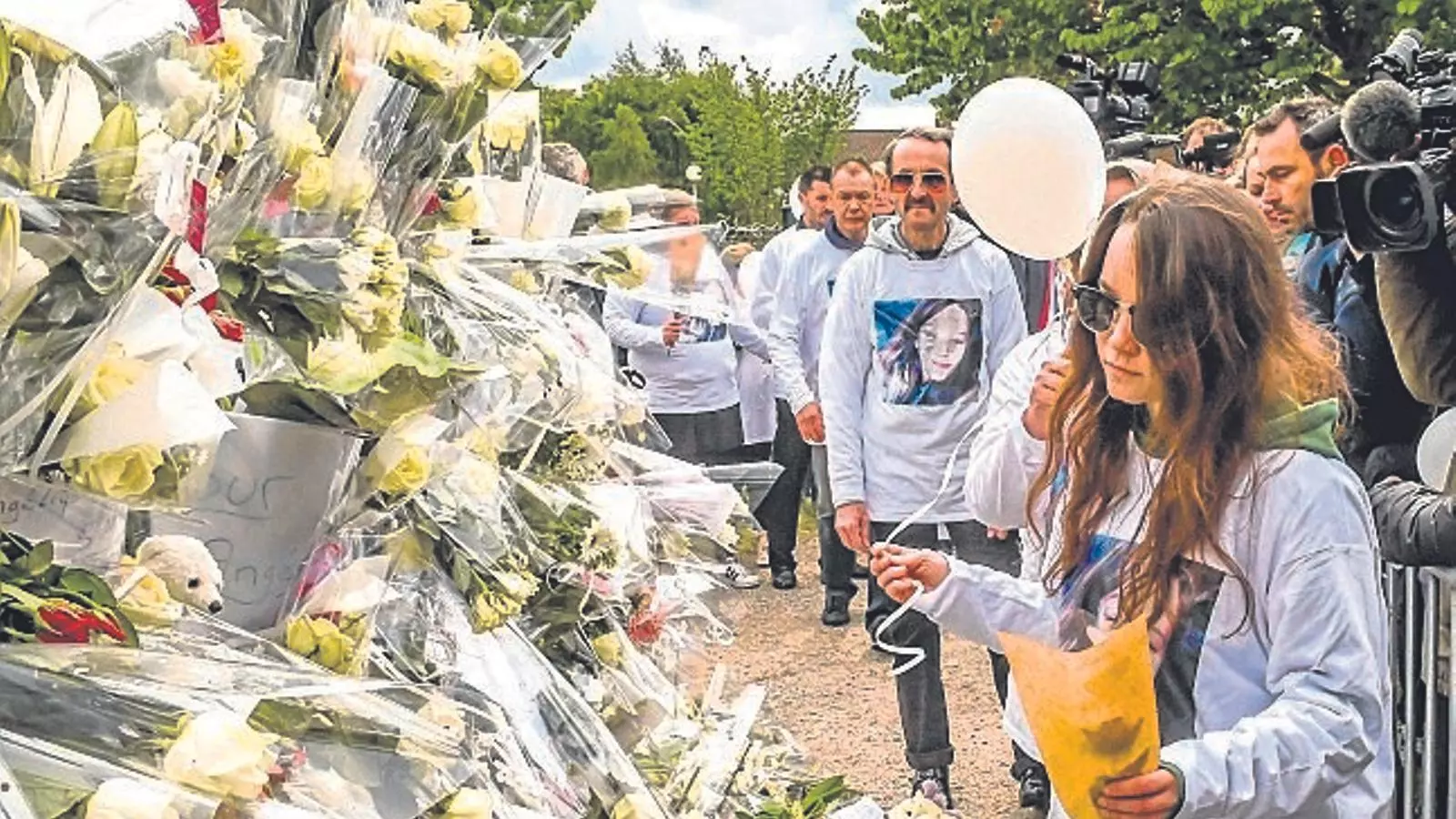 naïs, la germana d’Angélique, dipositant un ram de flors ahir en memòria de la nena