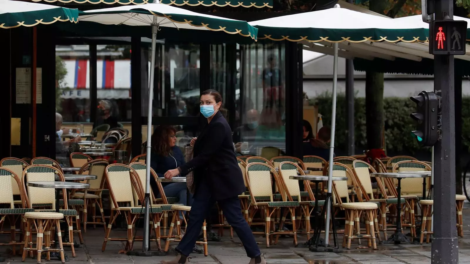 Una dona passeja per una zona plena de bars, ara tancats i amb moltes limitacions per frenar l'expansió de la pandèmia a París.