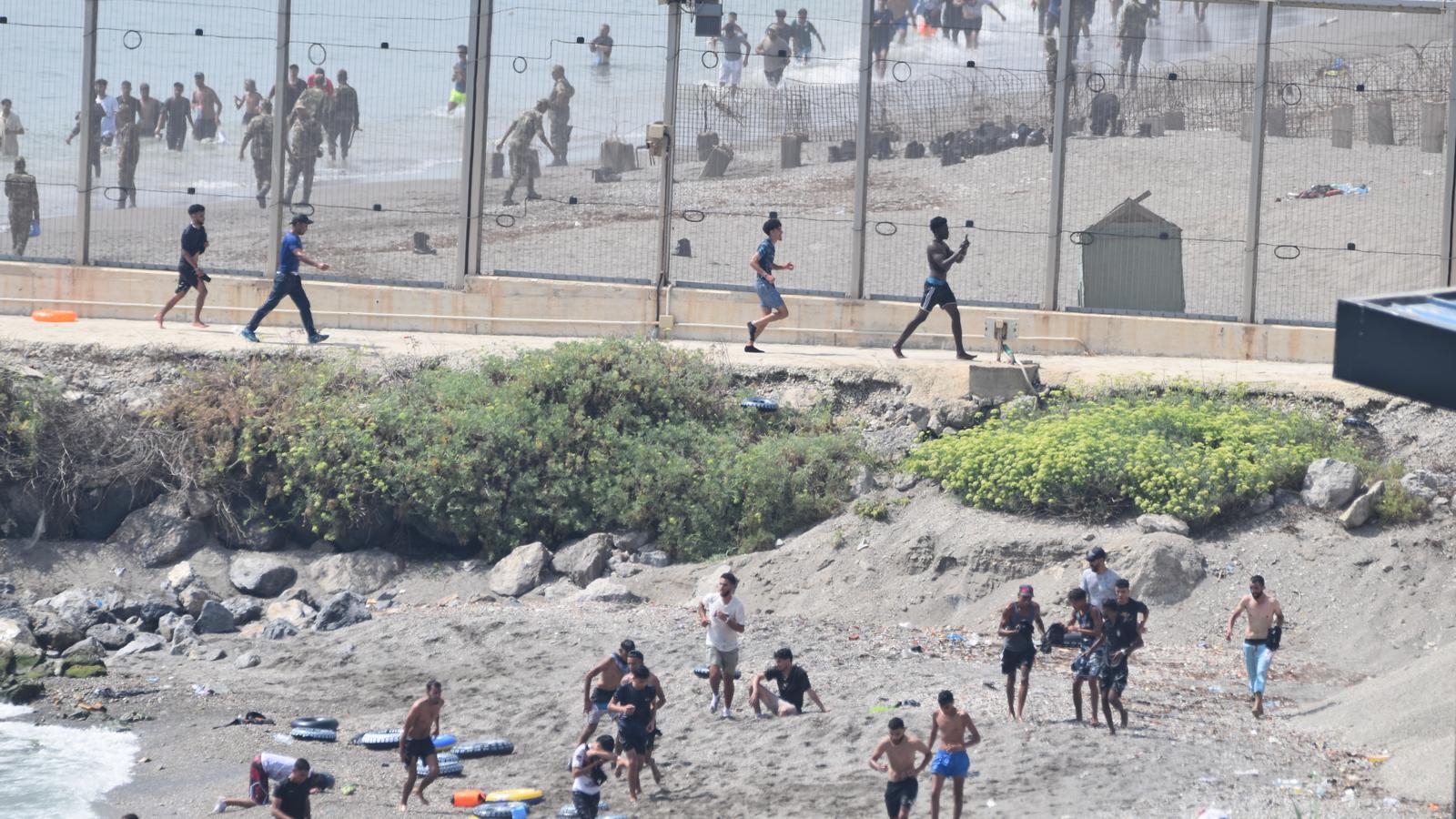 Young migrants try to cross the border of Ceuta this Thursday.