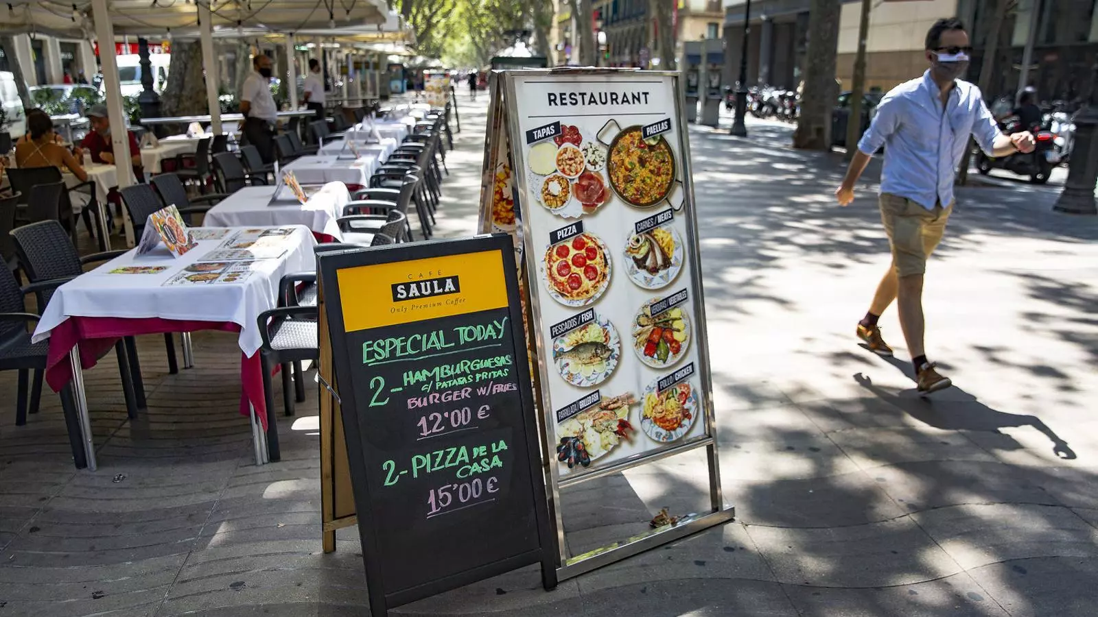 Terrasses pràcticament buides un migdia a la Rambla de Barcelona, malgrat les ofertes i la presència dels cambrers esperant per oferir el menú.