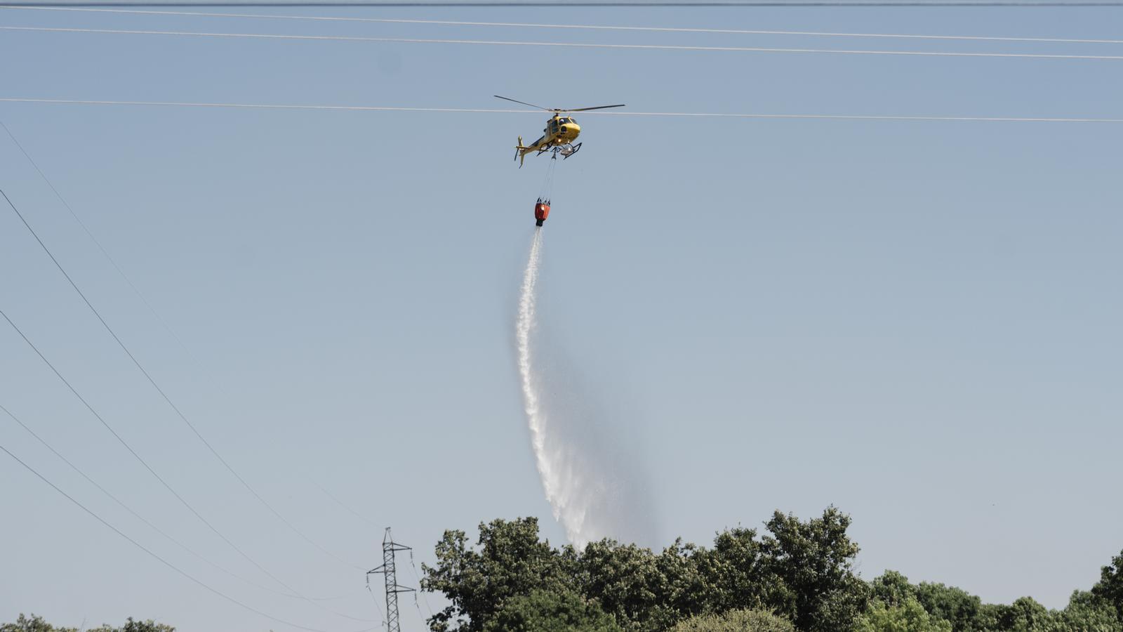 A helicopter works in the extinction of a fire in Lozoyuela (Madrid)