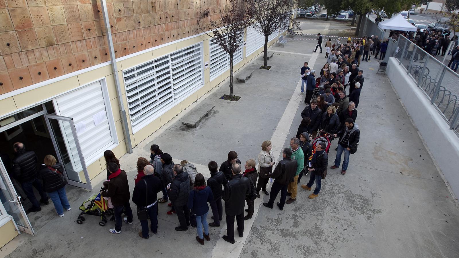 A dalt, voluntaris situant les paperetes en un dels col·legis del 9-N a Barcelona.  A baix, cues a la porta d’un dels instituts de la ciutat de Vic.