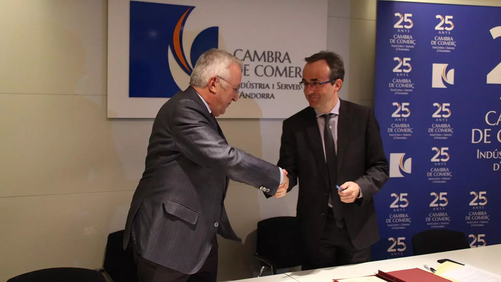 El president de la Cambra, Miquel Armengol i el director general adjunt de BancSabadell d'Andorra, Josep Segura es donen la mà després de signar l'acord. / B. N. (ANA)