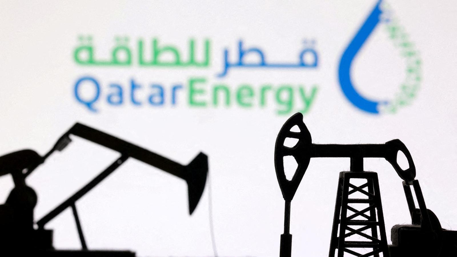 Maquinaria de bombeo de gas, delante del logo de QatarEnergy.