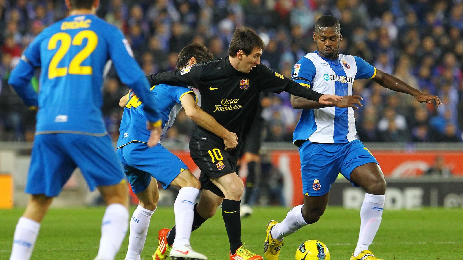 INOFENSIU Leo Messi evita l'entrada de Romaric en una jugada del derbi de Cornellà-El Prat.