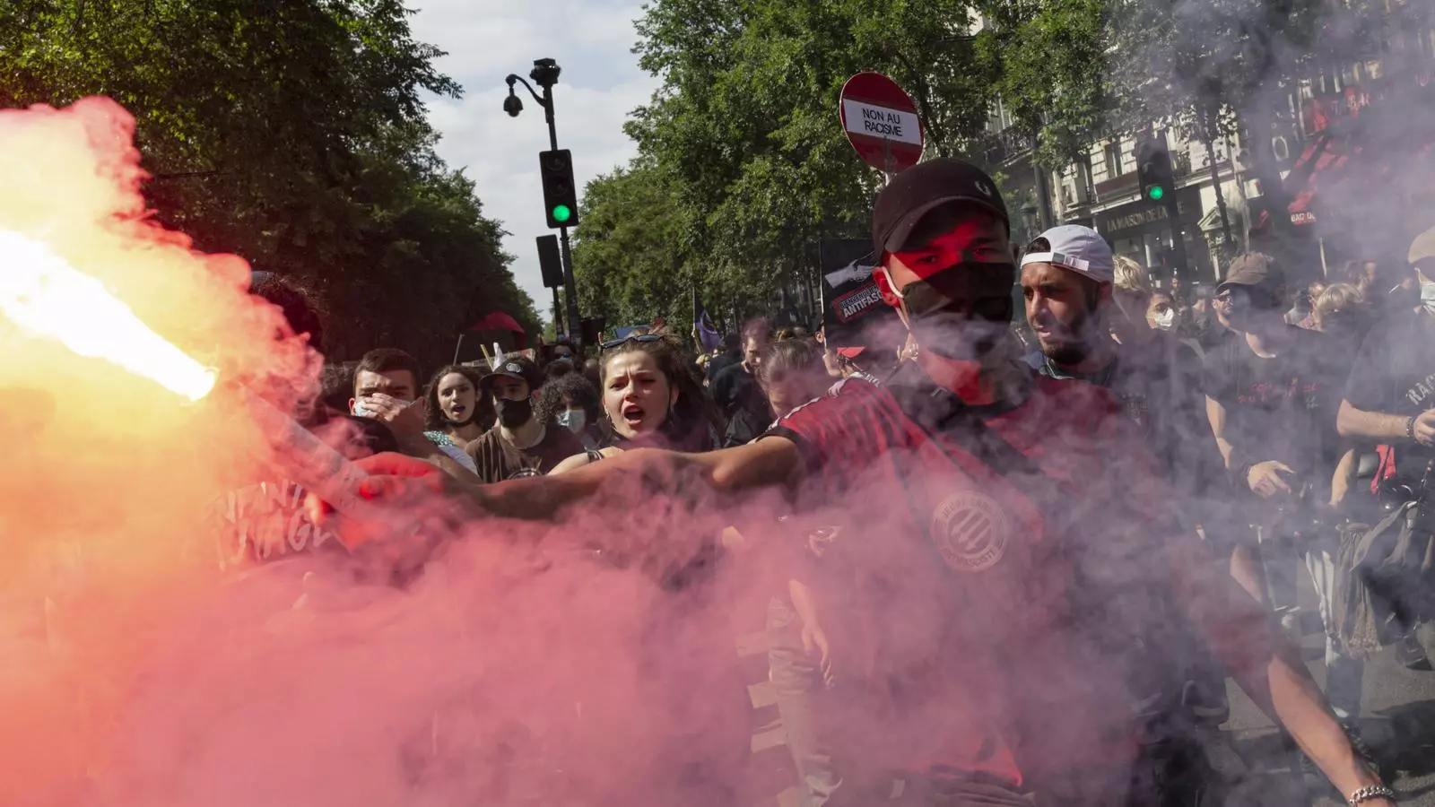 Un activista encén una bengala durant la marxa de les llibertats, la manifestació contra l'extrema dreta