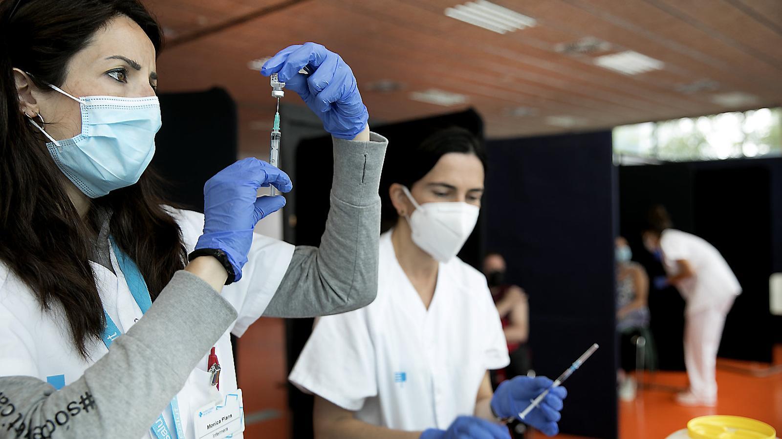 Sanitàries preparing doses of vaccines against covid -19.