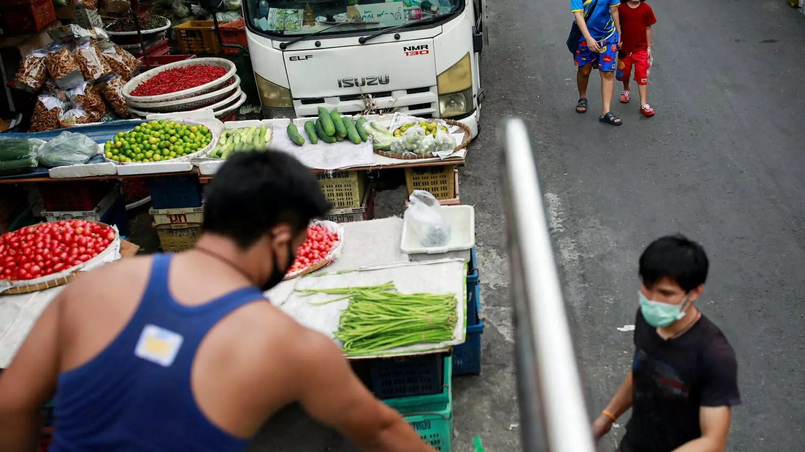 Treballadors amb mascareta descarregant vegetals en un mercat de Bangkok, a Tailàndia, un país que ha vist com es reduïa molt el turisme i on molts treballadors immigrants han decidit tornar als seus països.