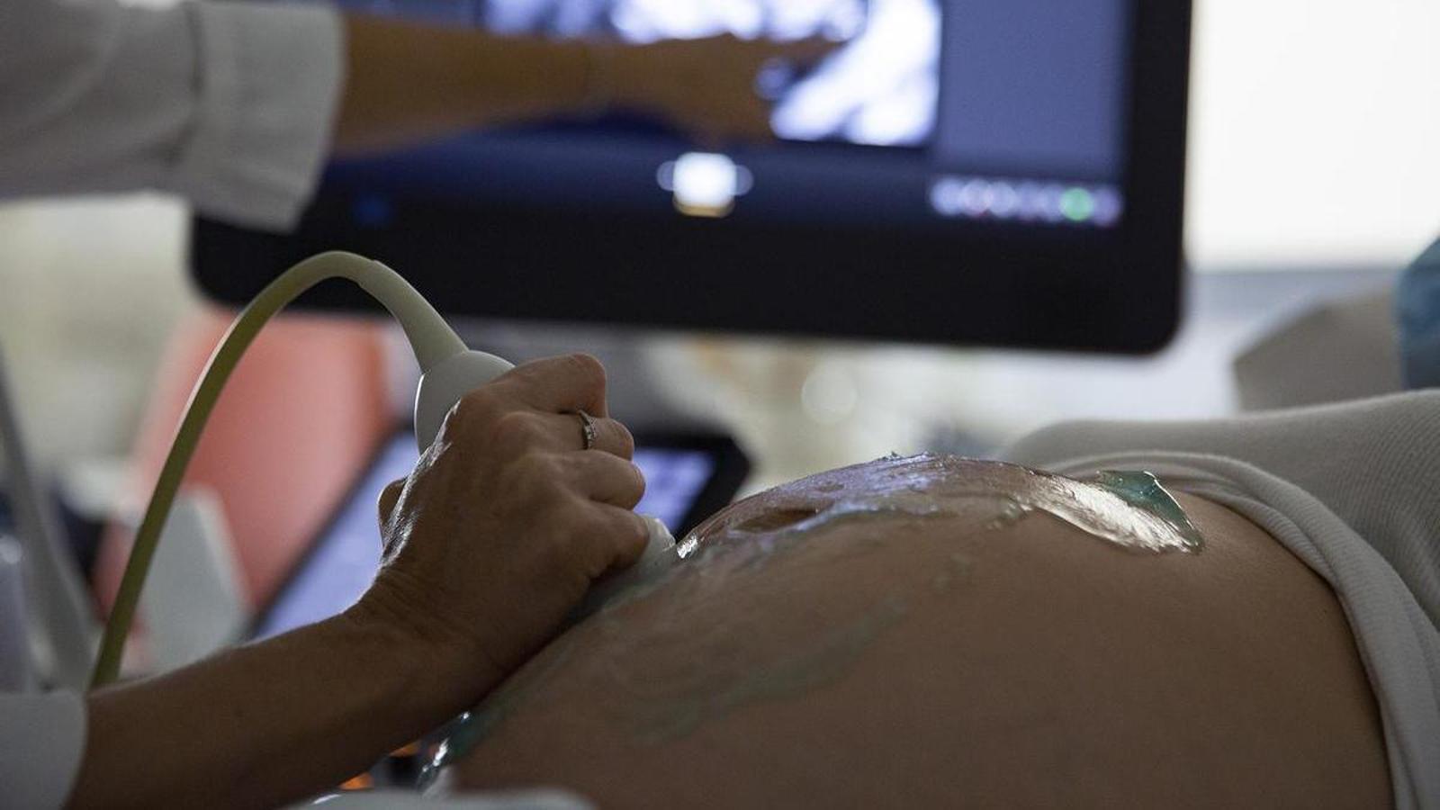A pregnant woman undergoes an ultrasound, in a stock image