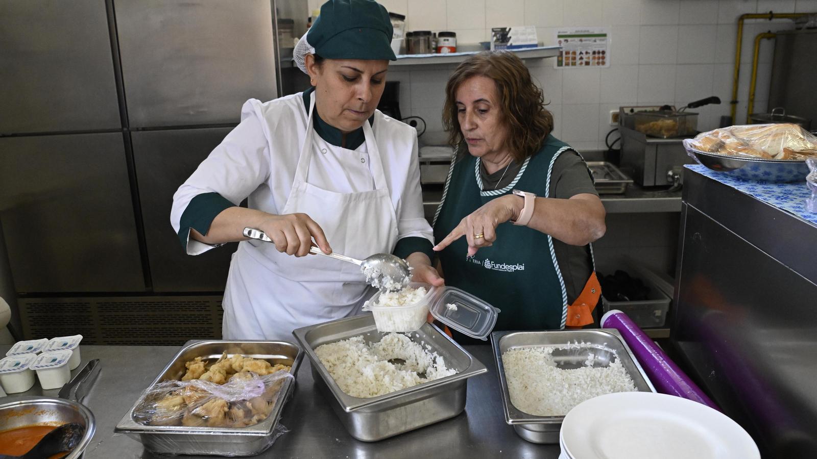 Personal de cocina preparando los menús para repartir