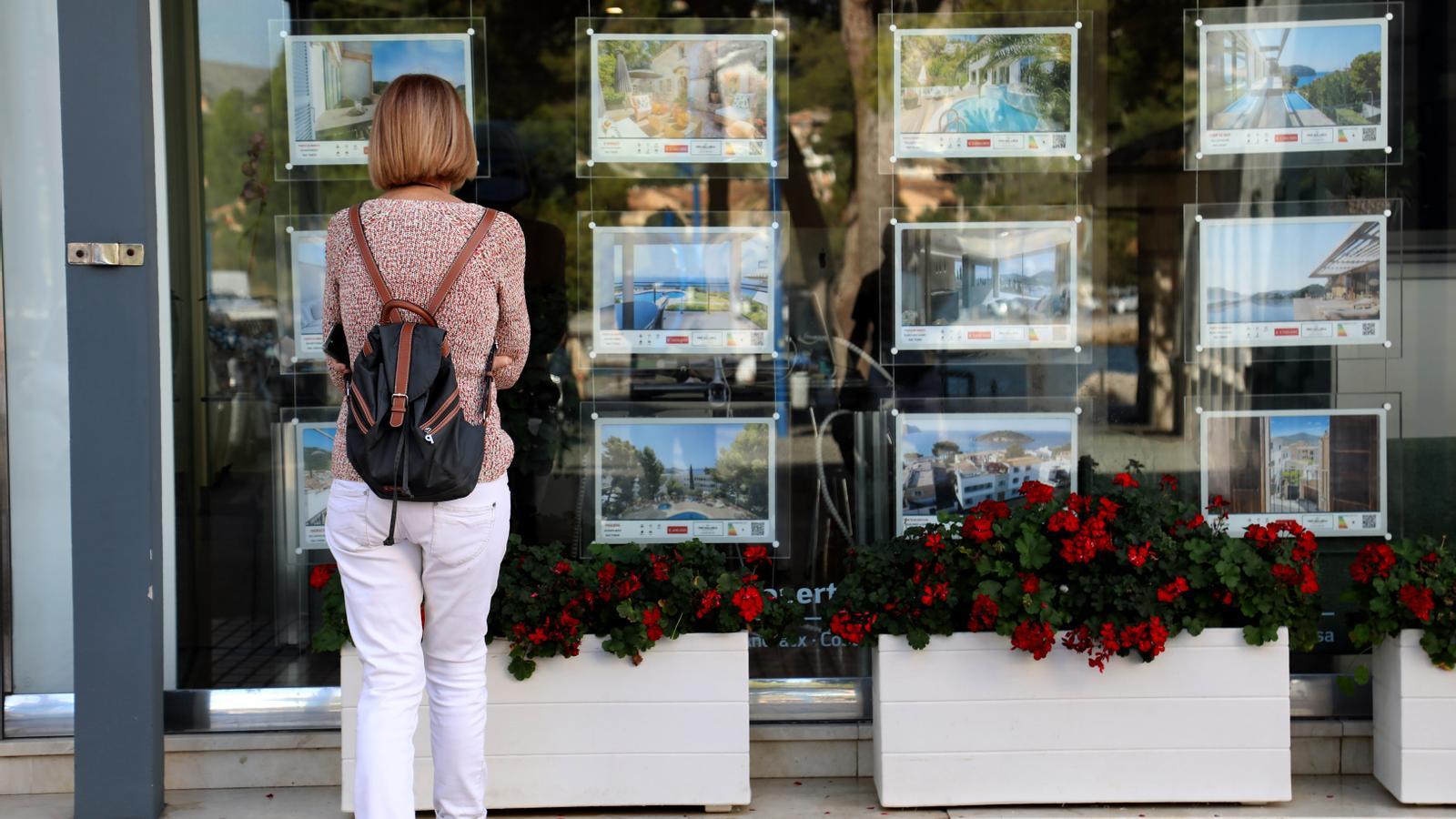Una dona davant una immobiliària del Port de Andratx.