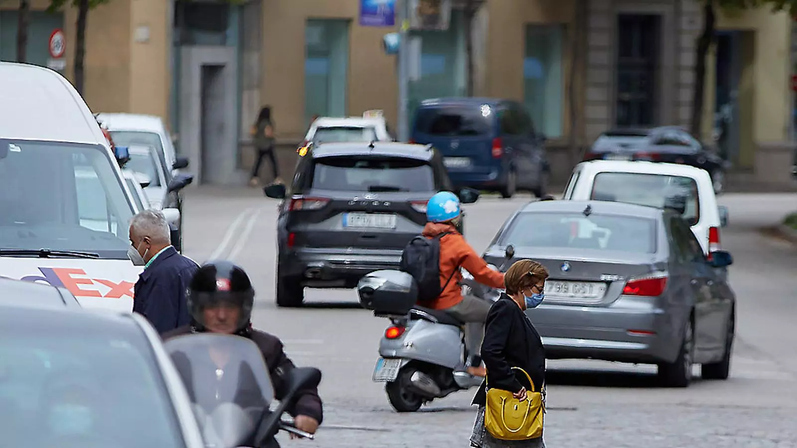 Ciclistes al carril bici que hi ha sota el viaducte del tren i un pas de vianants al centre urbà de Girona.