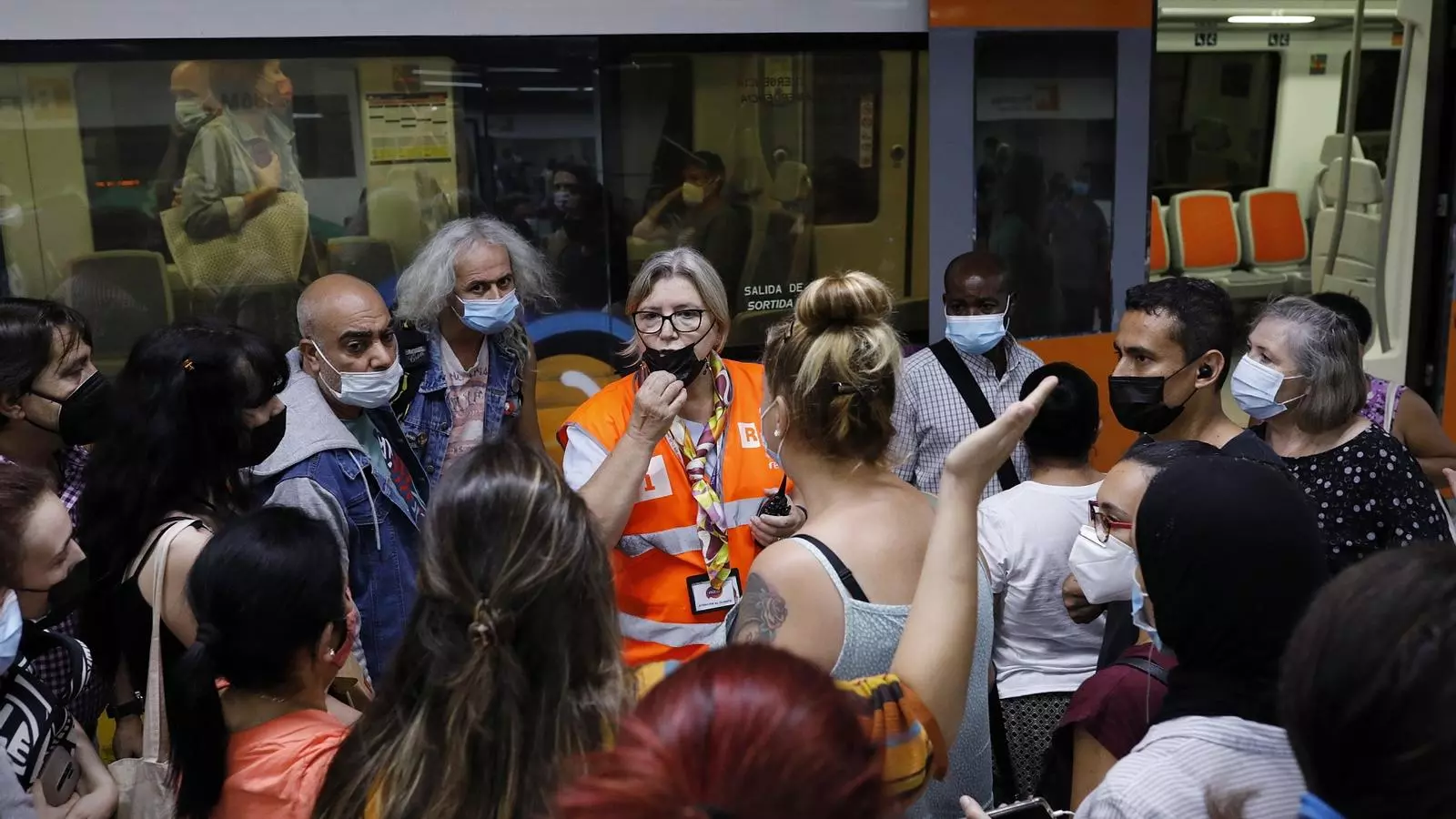 Una trabajadora del servicio de información de Renfe atendiendo un grupo de usuarios