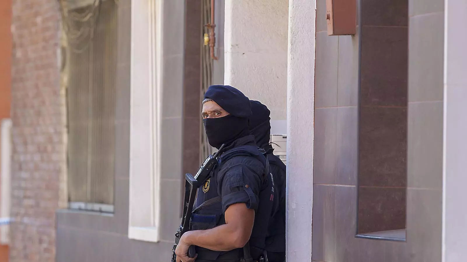 Un agent dels Mossos amb una arma llarga en el dispositiu d’ahir a Cornellà, abans que comencés l’escorcoll al pis del jove abatut.