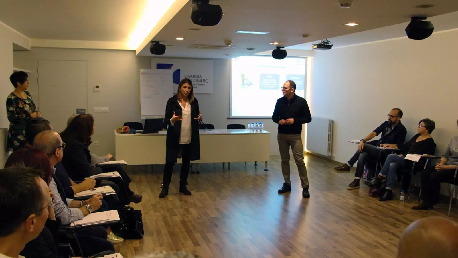 La secretària d’Estat de Comerç i Competitivitat, Neus Soriano, i el director de Formació Professional, Formació d'Adults i Recursos Educatius, Quim Torredà, parlen amb els alumnes de la segona edició del curs bàsic per a professionals del comerç. / T. N. (ANA)