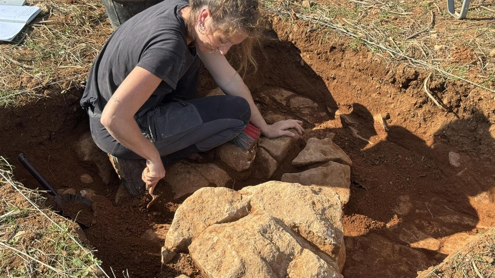 Una arqueòloga fa feina a una excavació.
