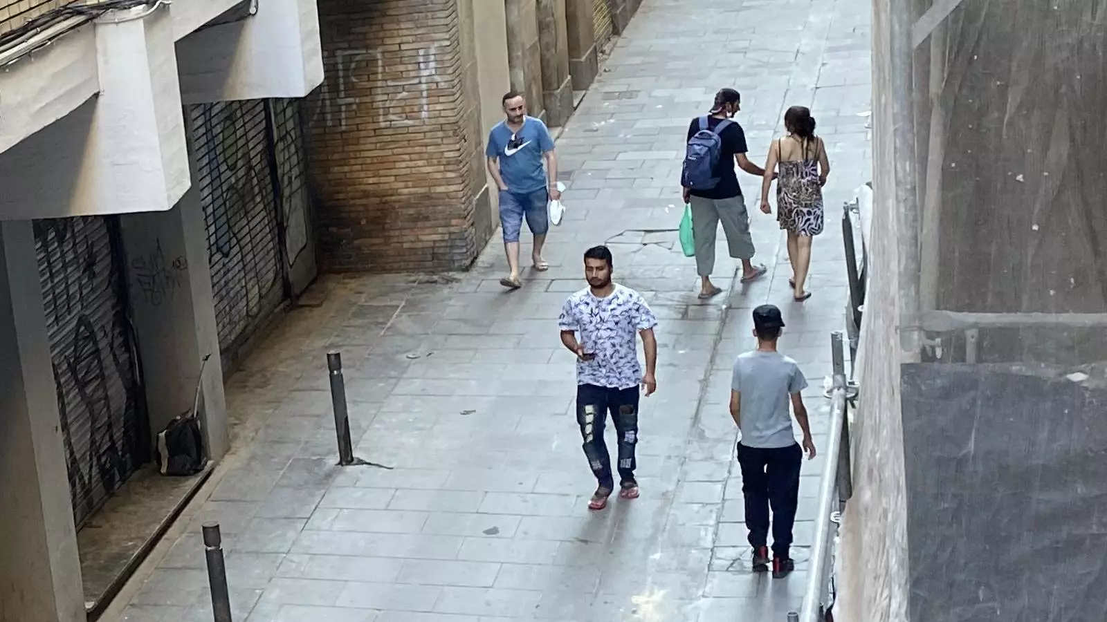 La presumpta venedora de drogues de Reina Amàlia 13, d'esquenes, parlant amb un client a començaments de juliol.