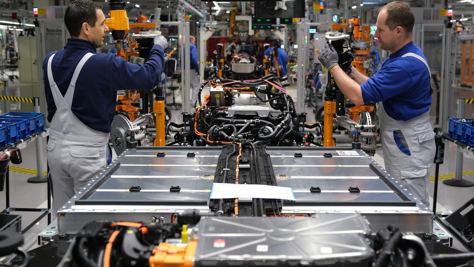 Unos trabajadores montan la parte inferior —que incluye la batería y el motor— de un coche eléctrico en la cadena de montaje de la fábrica de Volkswagen en Zwickau, Alemania, en una imagen de archivo