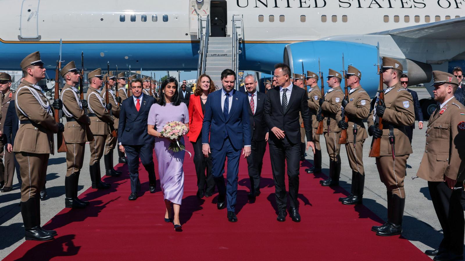 El vicepresidente de los EE.UU., J.D. Vance y su mujer, Usha Vance, recibidos por el ministro de Exteriores húngaro, Peter Szijjarto, en el aeropuerto de Budapest.