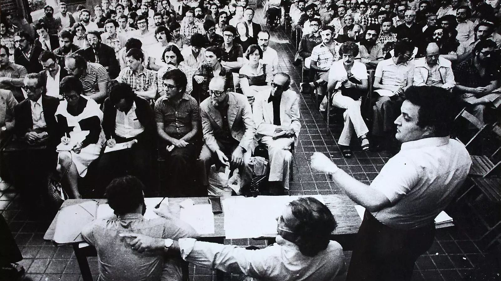 Reunió de l’Assemblea de Catalunya del 29 d’agost del 1976 al monestir de Pedralbes. A primera fila hi ha Josep Benet, Jordi Carbonell i Xavier Folch. Dret, Miquel Sellarès, i al seu costat, Pere Portabella.